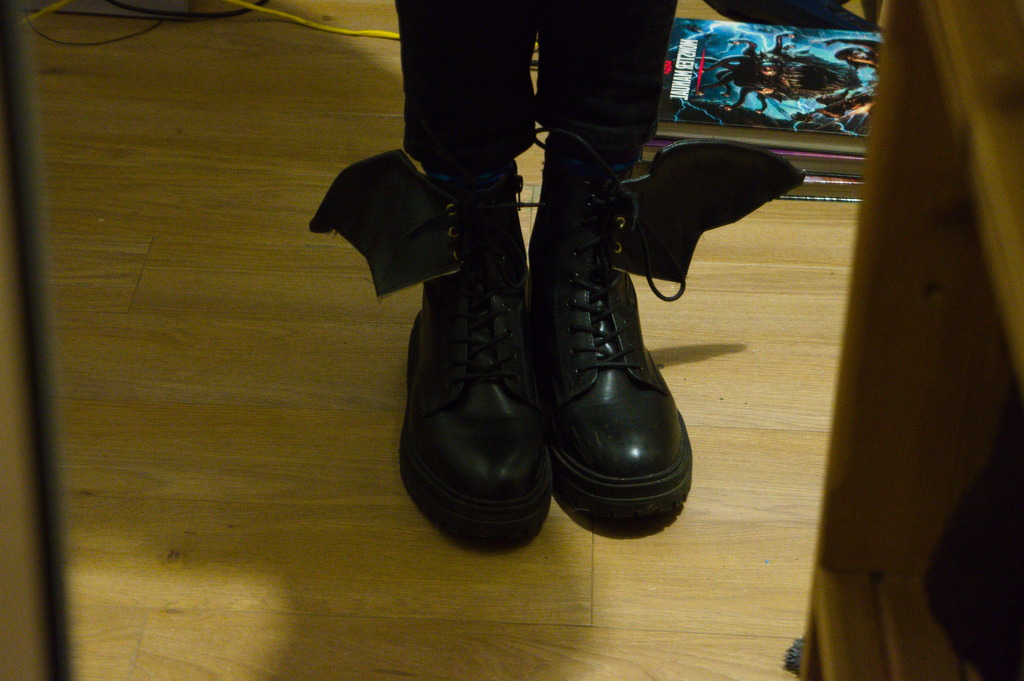 Image: My boots, a pair of faux-leather black boots with bat wings attached to them 